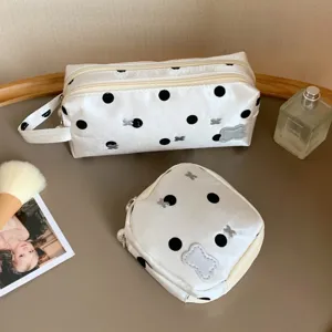Close-up of white polka dot pencil case and matching pouch in a lifestyle setting