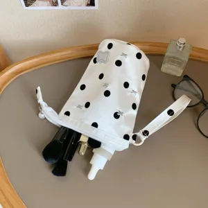 Detailed view of large capacity polka dot pouch containing makeup brushes and skincare.