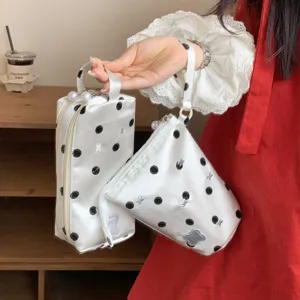 Detail view of polka dot satin pencil case and wristlet pouch with bear patches