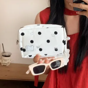 Detail view of a white polka dot stationery pouch with cute silver bow and pearl zipper
