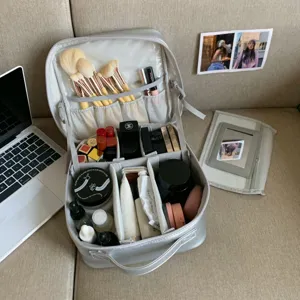 Detailed interior view of a partitioned gray PU makeup bag with brushes and cosmetics