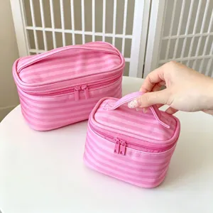 Detailansicht eines rosa gestreiften Kosmetiktaschen-Sets auf einem weißen Tisch