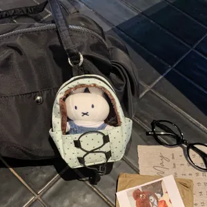 Close-up detail of mini polka dot backpack keychain with a cute white rabbit doll
