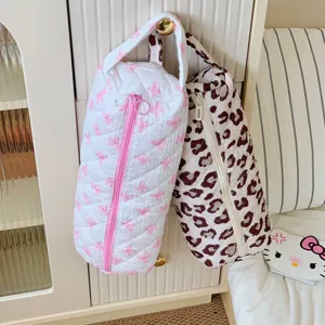 Detailed view of two large quilted storage bags for hair dryers and styling tools hanging