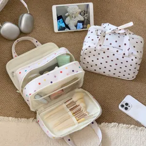 Detailansicht einer weißen gepunkteten dreischichtigen Kosmetiktasche mit Innenfächern