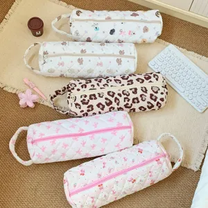 Close-up of quilted storage bags featuring bear, bow, and leopard prints for hair tools