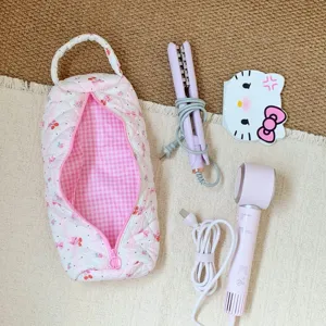 Quilted floral storage bag for hairdryer and styling tools shown with accessories