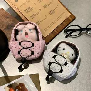 Detail view of mini polka dot backpack display cases with cute plush doll keychains.