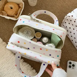 Detaillierte Ansicht der dreilagigen gepunkteten Kosmetiktasche mit verschiedenen Inhalten
