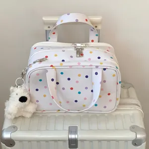 Detailansicht der weißen Polka-Dot-Kosmetiktasche mit drei Lagen und Bärenanhänger
