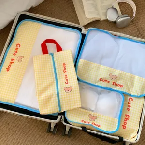 Detailed view of yellow checkered mesh travel storage bags inside a suitcase
