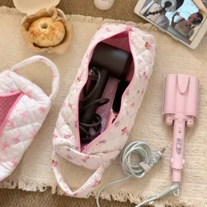 Large capacity quilted storage bag holding a hairdryer and styling tools