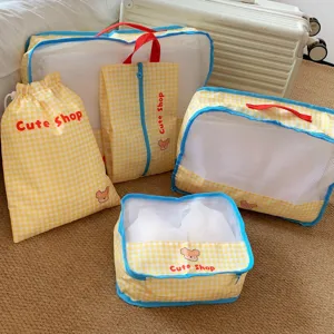 Variety of yellow checkered travel organizers and mesh bags displayed in a hotel setting