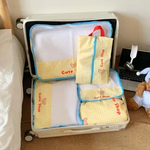 Yellow checkered mesh travel organizer bags in suitcase with a cute bear design