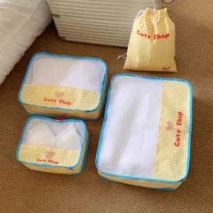 Set of 4 yellow checkered mesh travel packing cubes including a drawstring bag