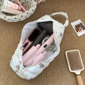 Detailed view of the large capacity quilted storage bag holding various hair styling tools