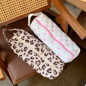 Detailed macro view of quilted hairdryer storage bags in leopard and pink bow patterns
