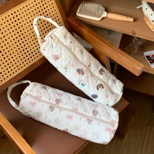 Detail of quilted cartoon storage bags for hair dryers and curling irons on chair