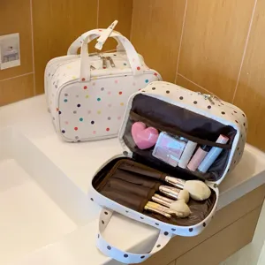 Detailansicht einer gepunkteten Kosmetiktasche mit organisierten Pinselhaltern und Make-up