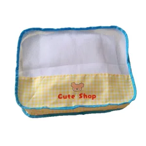 Portable mesh travel storage bag with yellow gingham design for clothes organization.