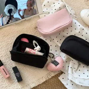 Detail showing inner compartments of a mini makeup bag with lipstick and cosmetics