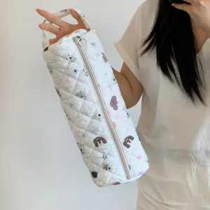 Close-up view of the quilted white storage bag with cartoon dog prints for hair dryers