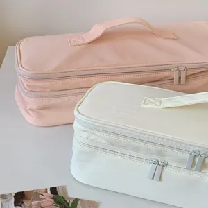 Close-up view of double-layer hair dryer storage bags in soft pink and cream white