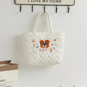 Detailed view of the cute dog embroidery and heart quilted texture on white handbag