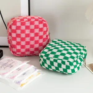 Détail de ces trousses à maquillage en tricot à damier aux tons rose et vert éclatants