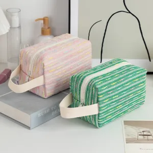 Close-up detail of large capacity tweed cosmetic bags with zip closure and handle straps