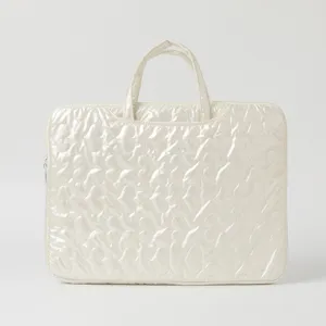 Close-up of cream quilted heart pattern laptop sleeve with top handles