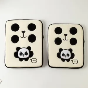 Vue détaillée de deux adorables housses d'ordinateur brodées de pandas en tailles différentes