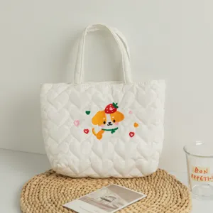 Close-up of white heart quilted tote bag with cute dog embroidery detail