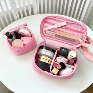 Nahaufnahme der rosa gestreiften Kosmetiktasche mit mehreren Fächern und Kosmetik.