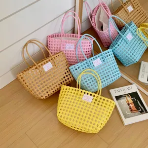 Bunte Dopamin handgewebte Strandtaschen aus Kunststoff auf einem schönen Holzboden