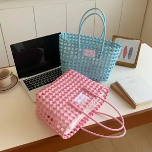 Detailansicht von handgewebten rosa und blauen Korbtragetaschen mit Textil-Innenfutter.