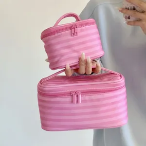 Detailansicht großer und kleiner rosa gestreifter Kosmetiktaschen mit praktischem Griff