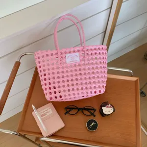 Rosa handgeflochtene Korbtasche auf Holztablett mit stilvollen Lifestyle-Accessoires