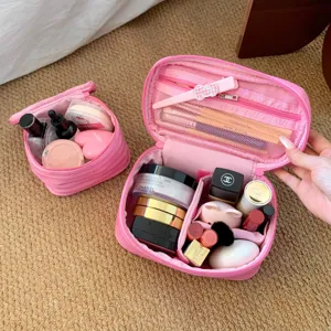 Detail der großen rosa gestreiften Kosmetiktasche mit hoher Kapazität und organisierten Fächern.