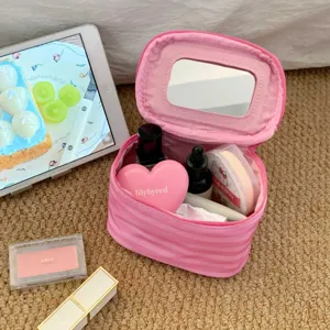 Nahaufnahme einer rosa gestreiften Kosmetiktasche mit Spiegel und großem Inhalt.