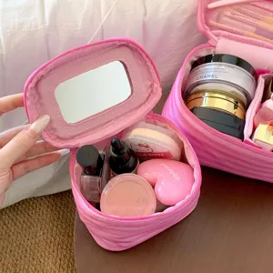 Detailansicht der rosa gestreiften Kosmetiktasche mit Spiegel und Make-up-Inhalt
