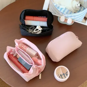 Interior detail of pink cosmetic pouch showing multiple compartments for lipsticks