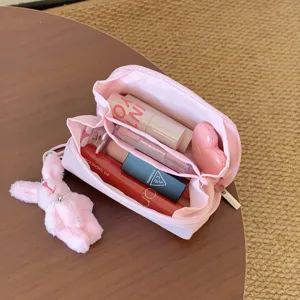 Portable pink mini lipstick organizer bag with multiple compartments and plush bunny charm