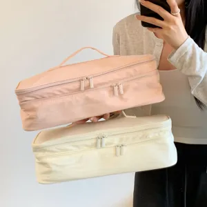 Detailed view of large capacity double-layer hair dryer storage bags in pink and cream