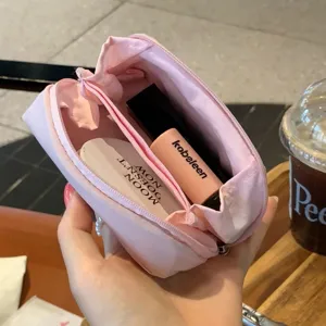 Close-up of pink mini cosmetic pouch showing internal compartments and storage space