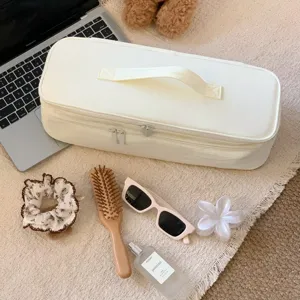 Detailed lifestyle view of a large capacity cream hair dryer storage bag with handle.