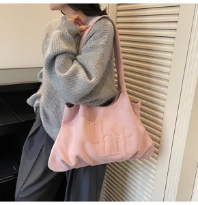 Roze suède draagtas met tht-logo gedragen door een model in een lifestyle-setting