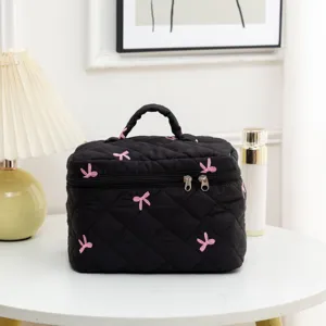Quilted black makeup bag with pink bow embroidery details and large storage capacity