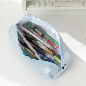 Large capacity blue quilted pencil case filled with pens for students desktop storage