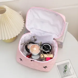 Detailed interior view of pink quilted makeup bag with bow embroidery and items